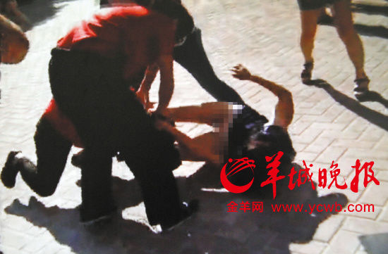 女业主被保安掀翻在地。记者 王俊伟 摄（翻拍视频）